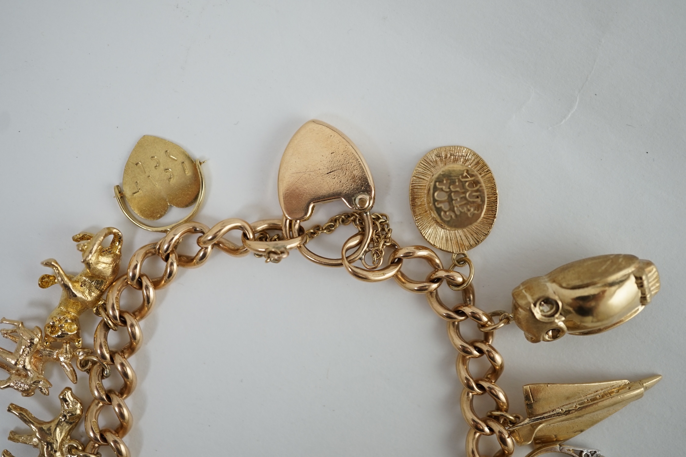 An early 20th century 15ct gold curb link charm bracelet